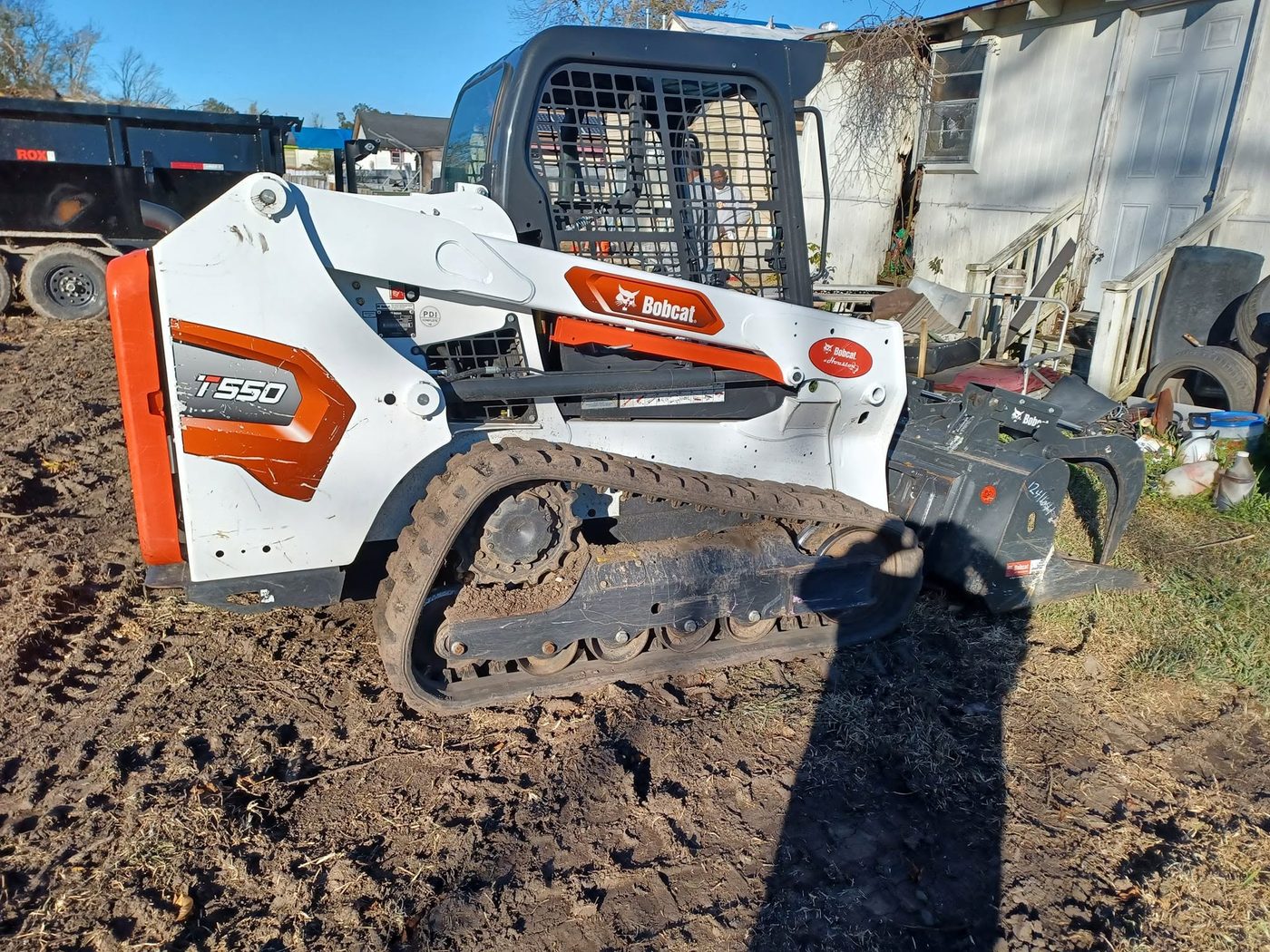 Bobcat T550 skid steer with clearing attachment on site